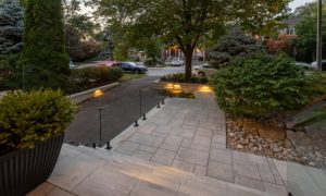 custom retaining wall with glass railings lighting toronto